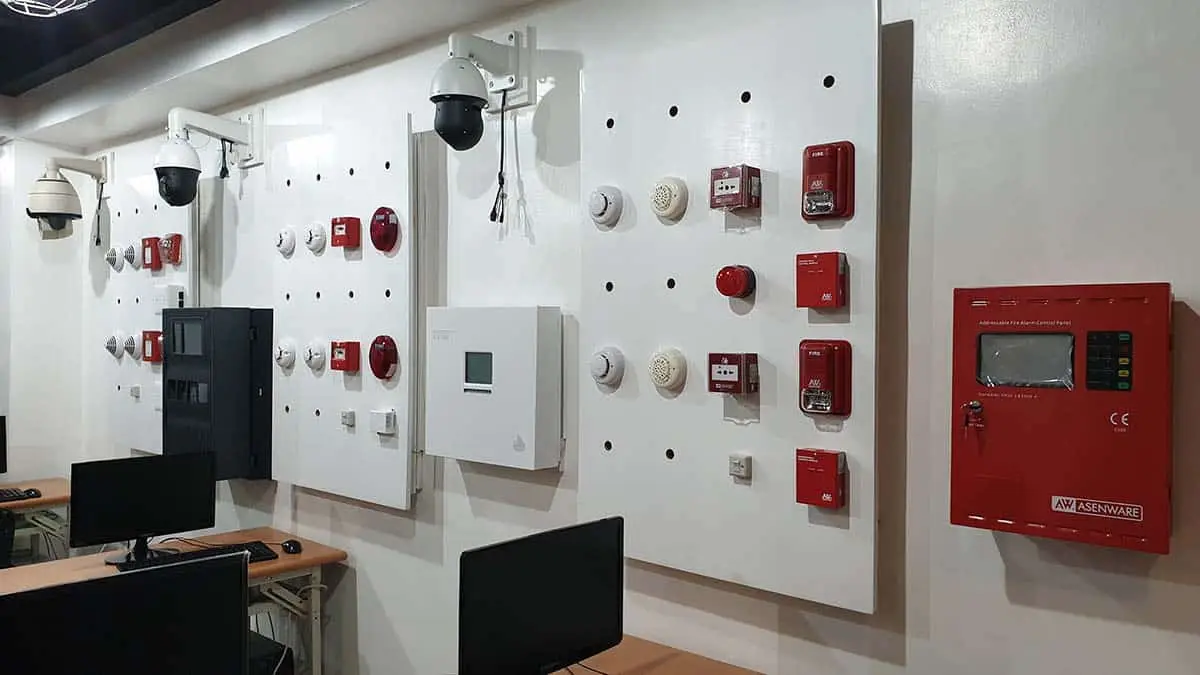 A professional technical training room in the Philippines equipped with fire alarm control panels, smoke detectors, and integrated CCTV systems for FDAS courses.